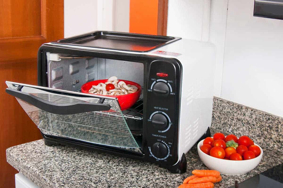 厨房环境中的烤面包机，里面有红碗bd手机下载的食物，小厨房里该把烤面包机放在哪里?