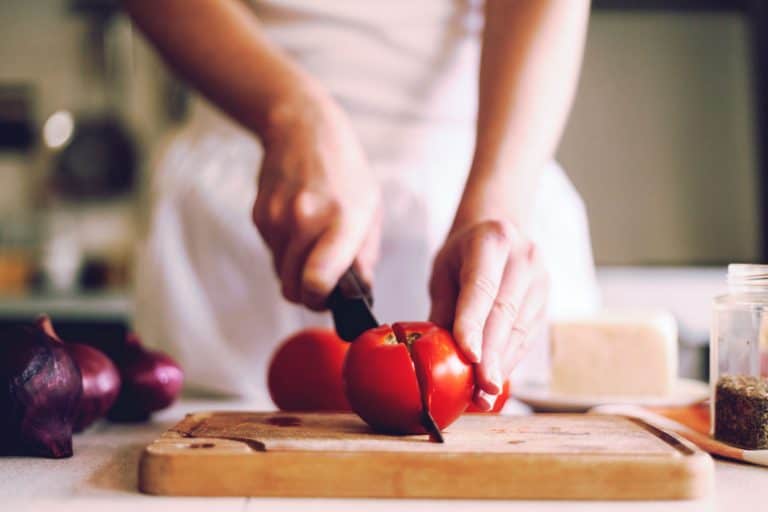 一个女人切一块西红柿切菜板,如何正确骰子番茄[3]方法