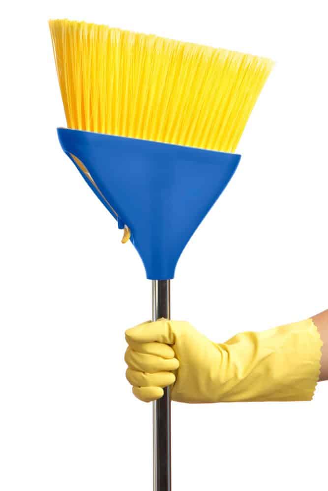 一个女人戴着黄色手套，拿着蓝色塑料刷扫帚