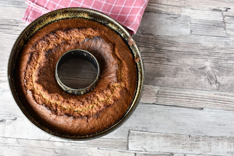 一块新鲜出炉的烤盘蛋糕放在木桌上,多久你烤蛋糕的圆盘的话?(加上一些流行的食谱!)