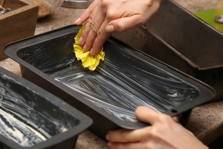 一个女人涂黄油之前把面团放在烤盘上,如何轻松地和彻底面粉一锅