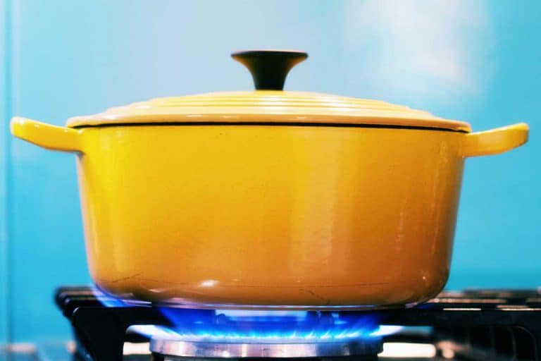 一个黄色的搪瓷砂锅，盖上盖子，放在一个点燃的煤气炉上，加热时产生蒸汽，Le Creuset陶瓷能上炉子吗?