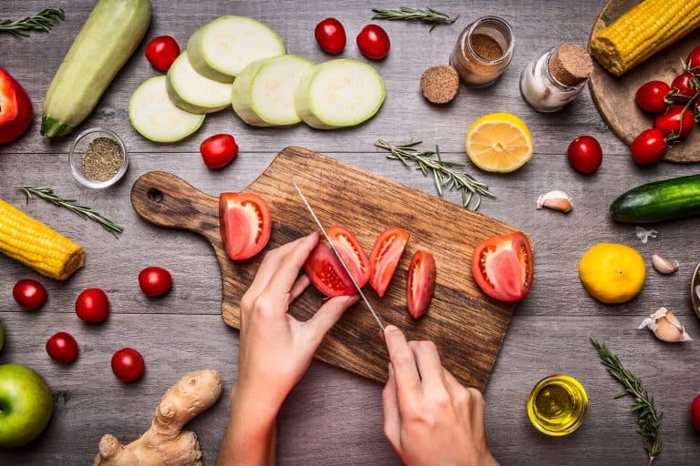 女手切西红柿乡村厨房的桌子上,在谎言成分,蔬菜,水果,和香料,健康食品bd手机下载,烹饪和素食的概念,什么是最好的刀切西红柿吗?