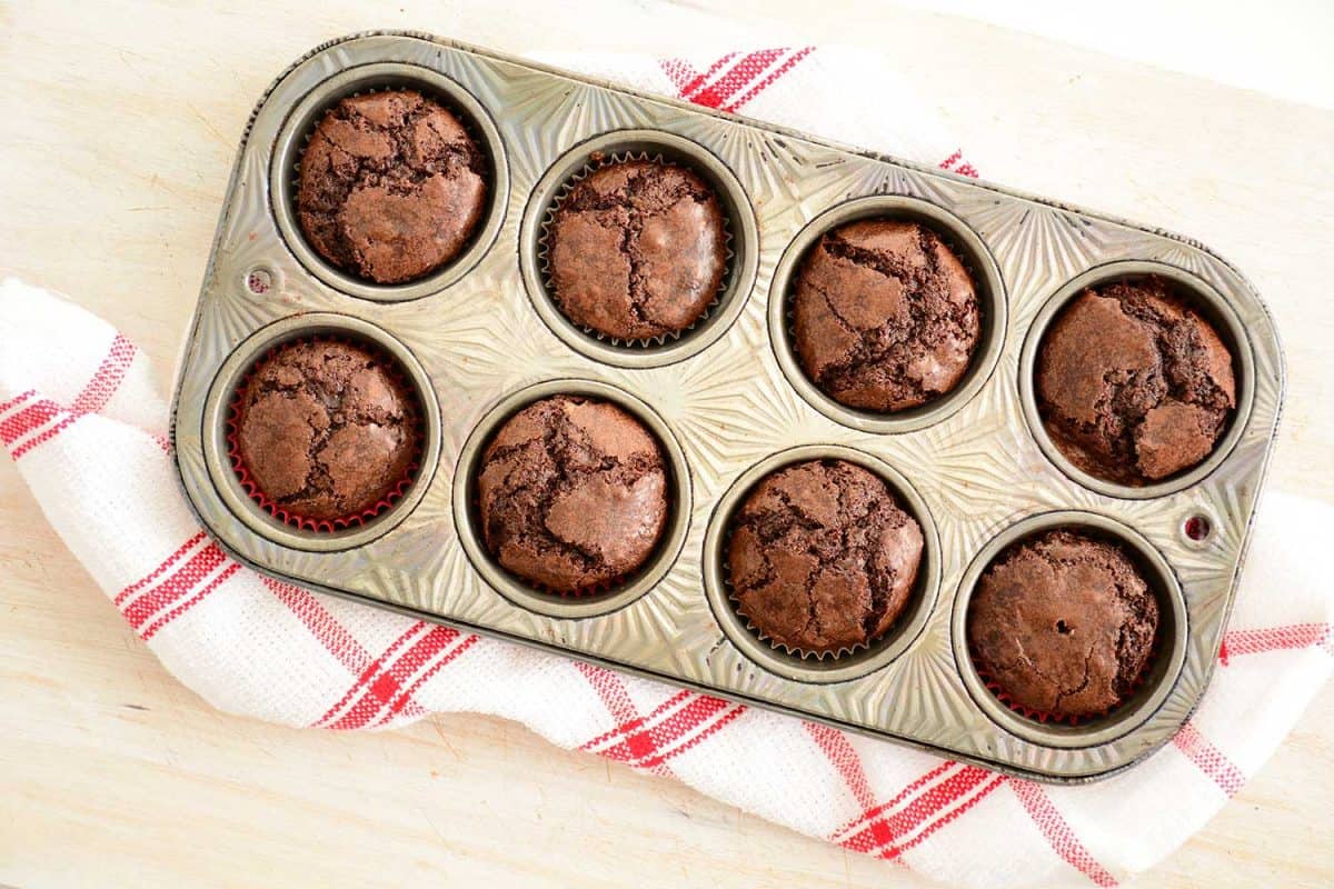 新鲜烘焙的迷你巧克力布朗尼在复古松饼锡上的红白茶巾平铺组成