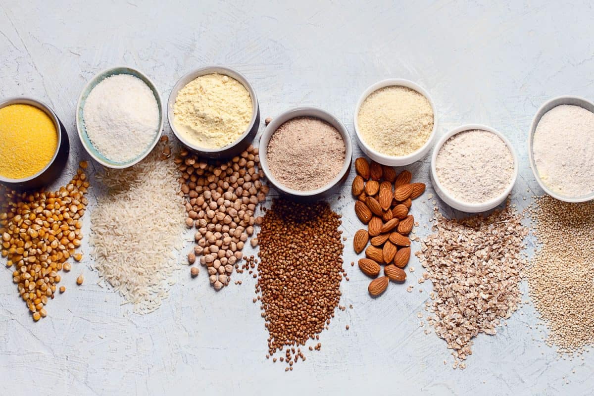 各种无麸质面粉-鹰嘴豆，大米，荞麦，藜麦，杏仁，玉米，燕麦灰色背景＂width=