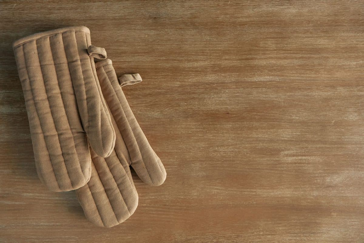 一副棕色的烤箱手套放在木桌上