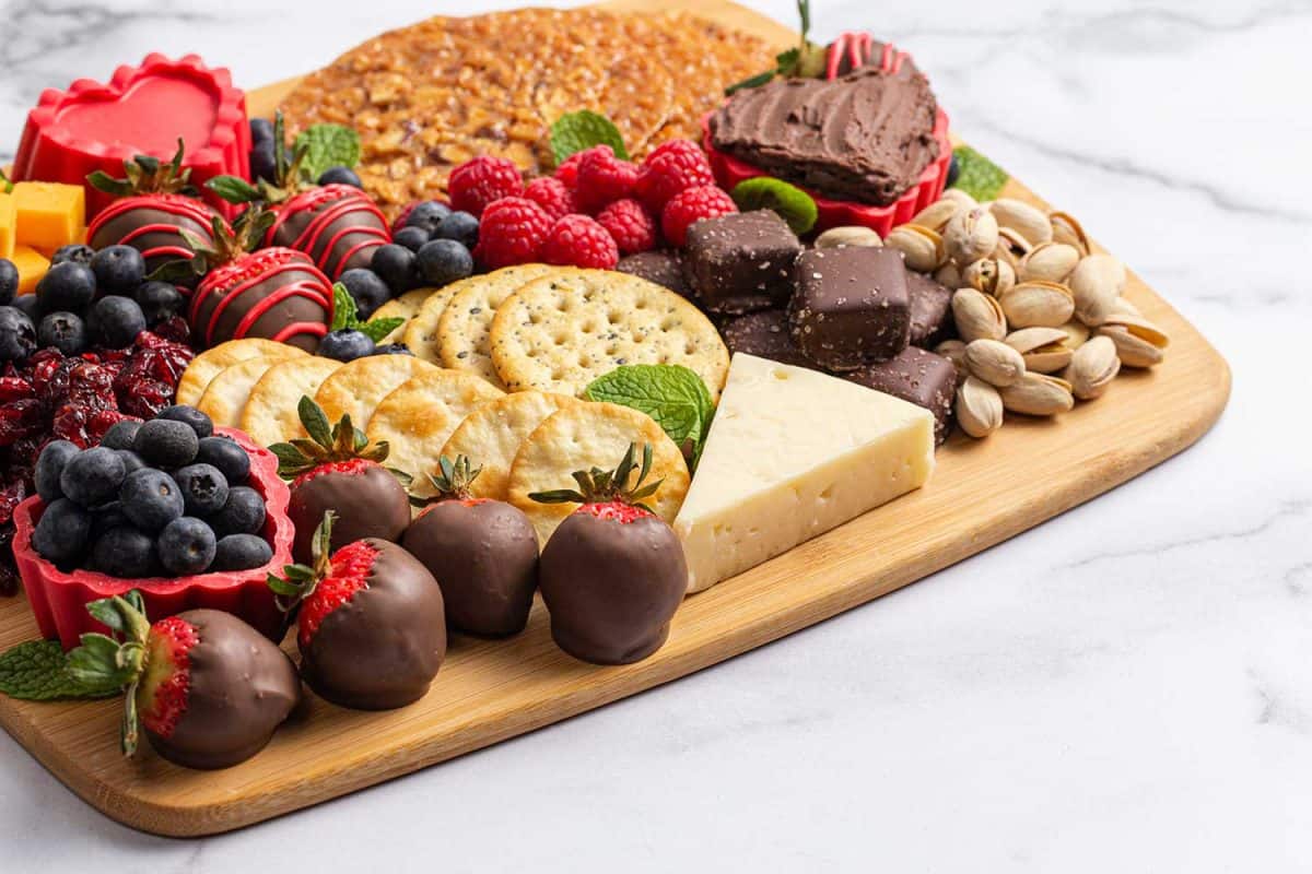 巧克力草莓和奶酪甜熟食板在大理石柜台上＂width=