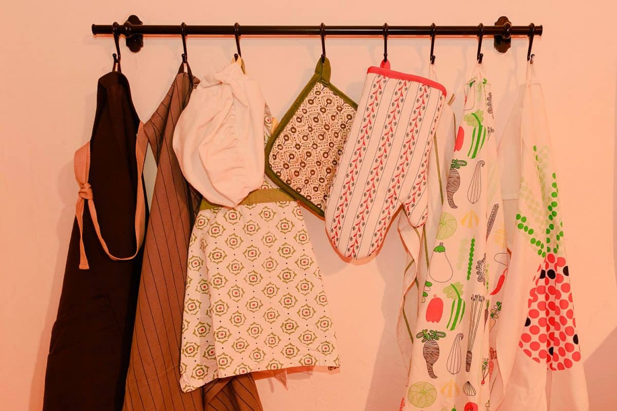 干净的围裙和烤箱手套挂在墙上