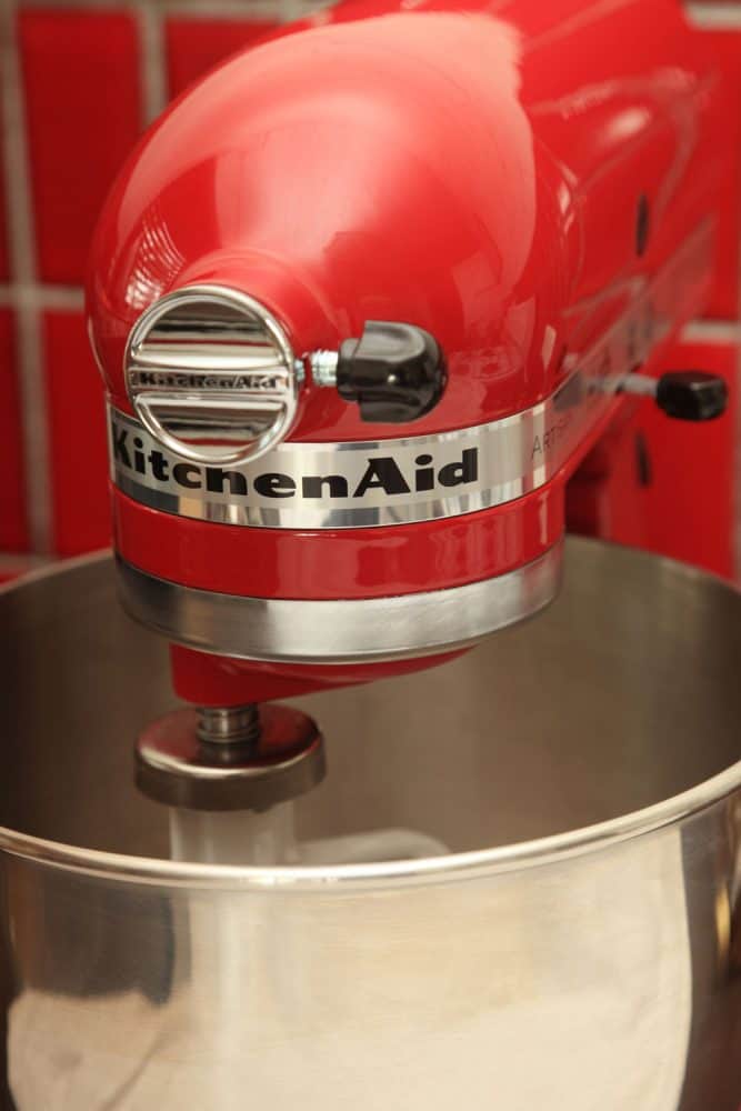 帝国红色的厨具工匠站搅拌机，红色瓷砖背景bd手机下载上的角度前视图与平搅拌器附件和碗