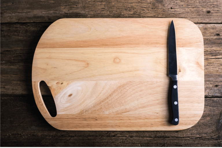 Empty-chopping-board-with-a-sharp-paring-knife-on-a-distressed-grunge-wooden-table-in-a-rustic-bd手机下载kitchen