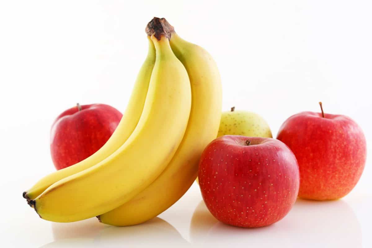 香蕉苹果旁边放在白色背景