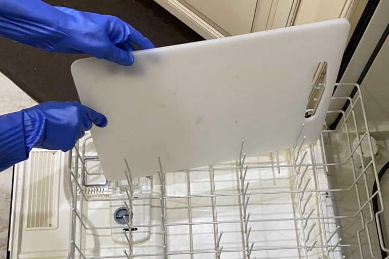 肮脏的砧板加载到一个空的洗碗机虽然戴着橡胶手套,是一个砧板洗碗机安全吗?