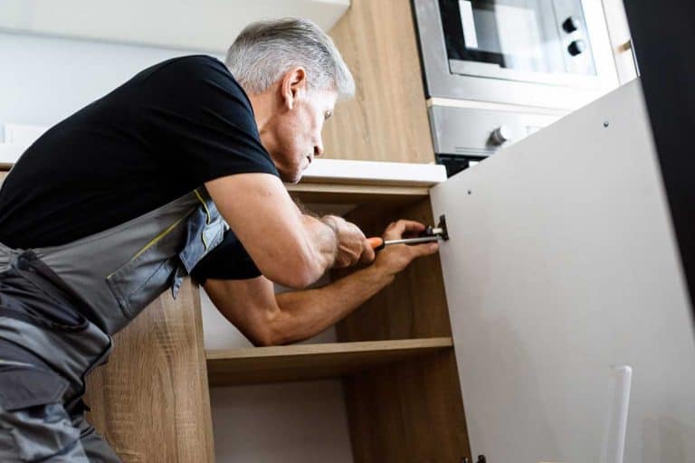 修理工在统一工作,修复橱柜使用螺丝刀,如何恢复厨柜和修复磨损的斑点bd手机下载