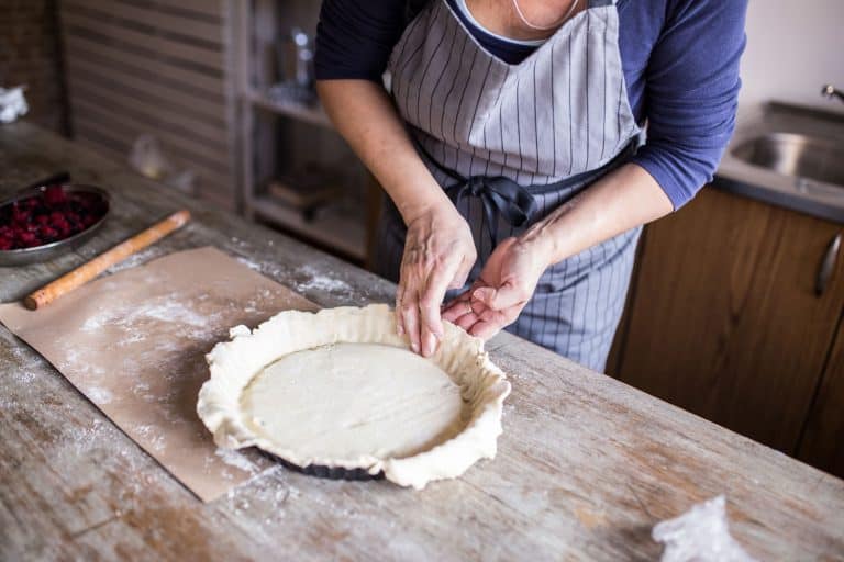 一个女人在她的厨房做一个美味的派,如何把面团放在一个馅饼盘(一个完整的指南)bd手机下载