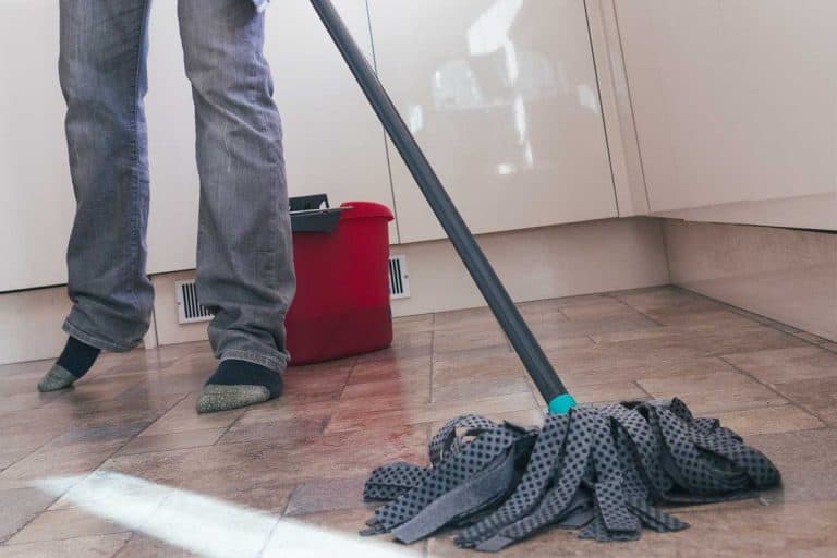 低角度的观点一个男人拖地板在他的厨房里,如何减少厨房地板上滑(与5个简单的方法)bd手机下载