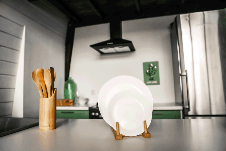 木制厨房用具在bd手机下载一个美丽的现代厨房的背景木玻璃白色搁架单元与一套餐具。如何储存锅铲- 8个创意解决方案!