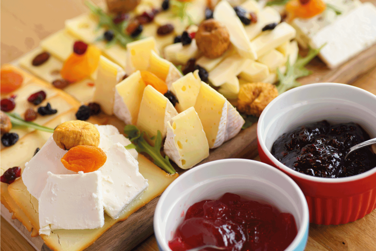 奶酪板上有各种奶酪，干果和果酱