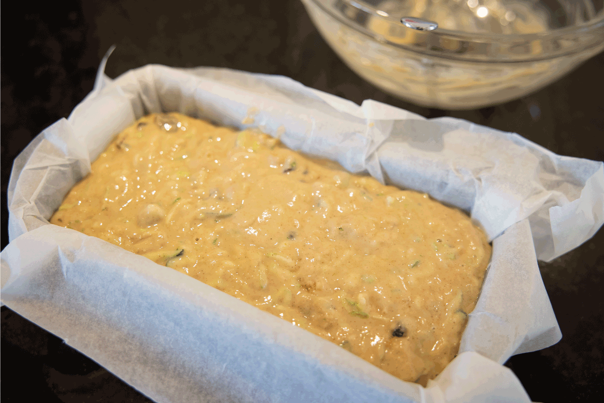 小胡瓜西葫芦蛋糕混合物在锡(烘烤前)。如何用羊皮纸或箔纸铺面包盘