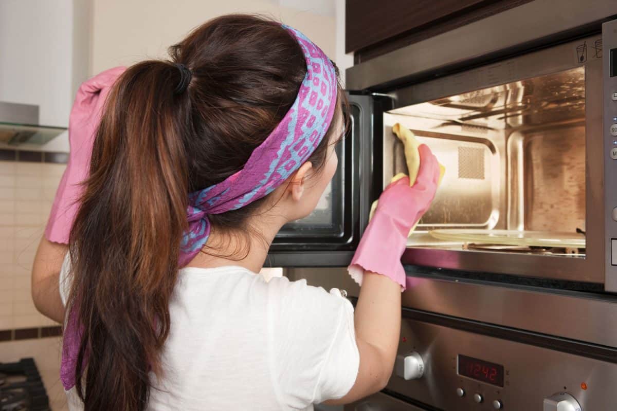 女孩在厨房清洁烤箱，如何清洁微波炉的油脂过滤器bd手机下载