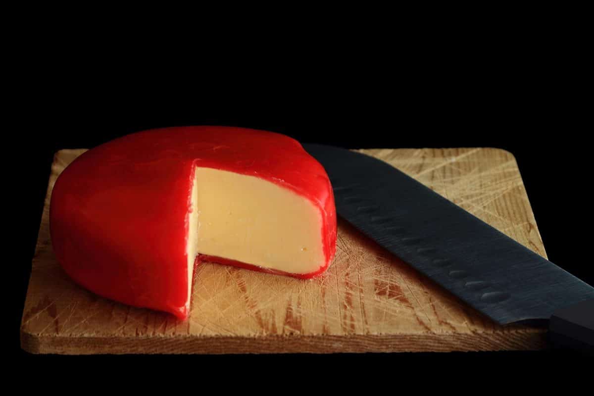 豪达奶酪轮覆盖红蜡保护层在木砧板