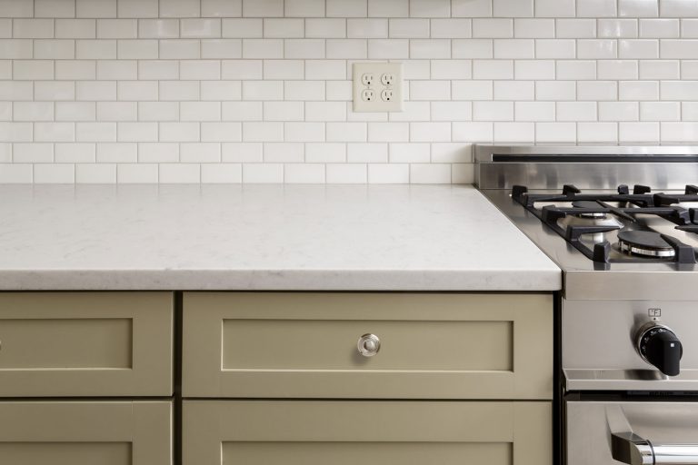 一张白色的厨房台面、浅灰色的橱柜和后挡bd手机下载板上的插座的照片，厨房台面插座和电灯开关应该有多高?