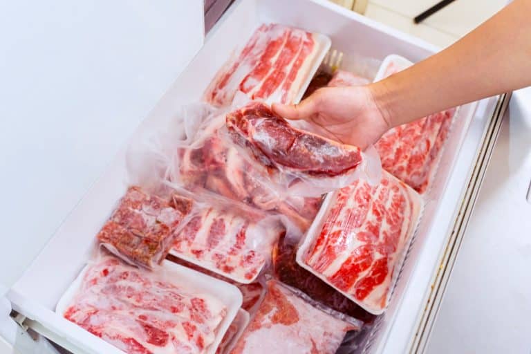 平坦的布局，人手从储藏室的冷冻箱中取出一包红肉，塑料包裹着，一整头牛的冷冻室有多大?