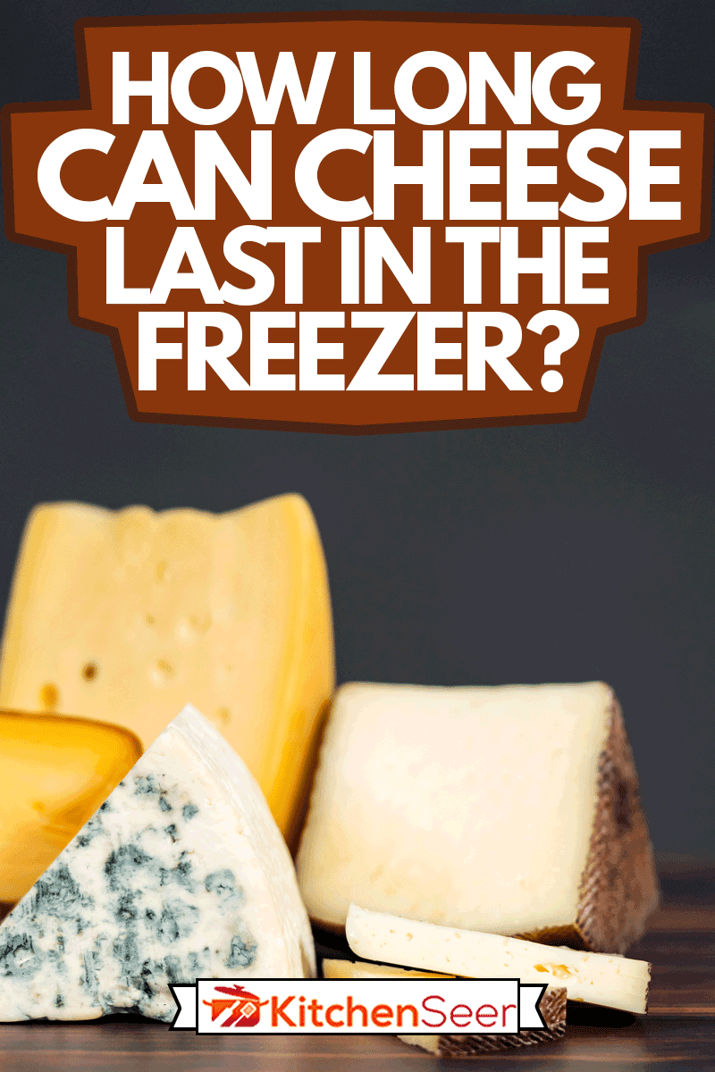 各种大的美食奶酪楔形在黑暗的木制背景，奶酪可以在冰箱里保存多久?