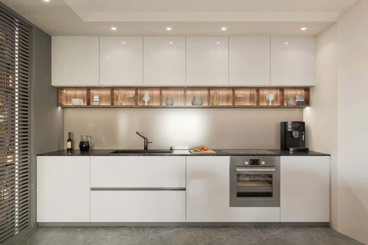 狭窄而现代的厨房区，白色玻璃橱柜和白色橱bd手机下载柜，灰色地板