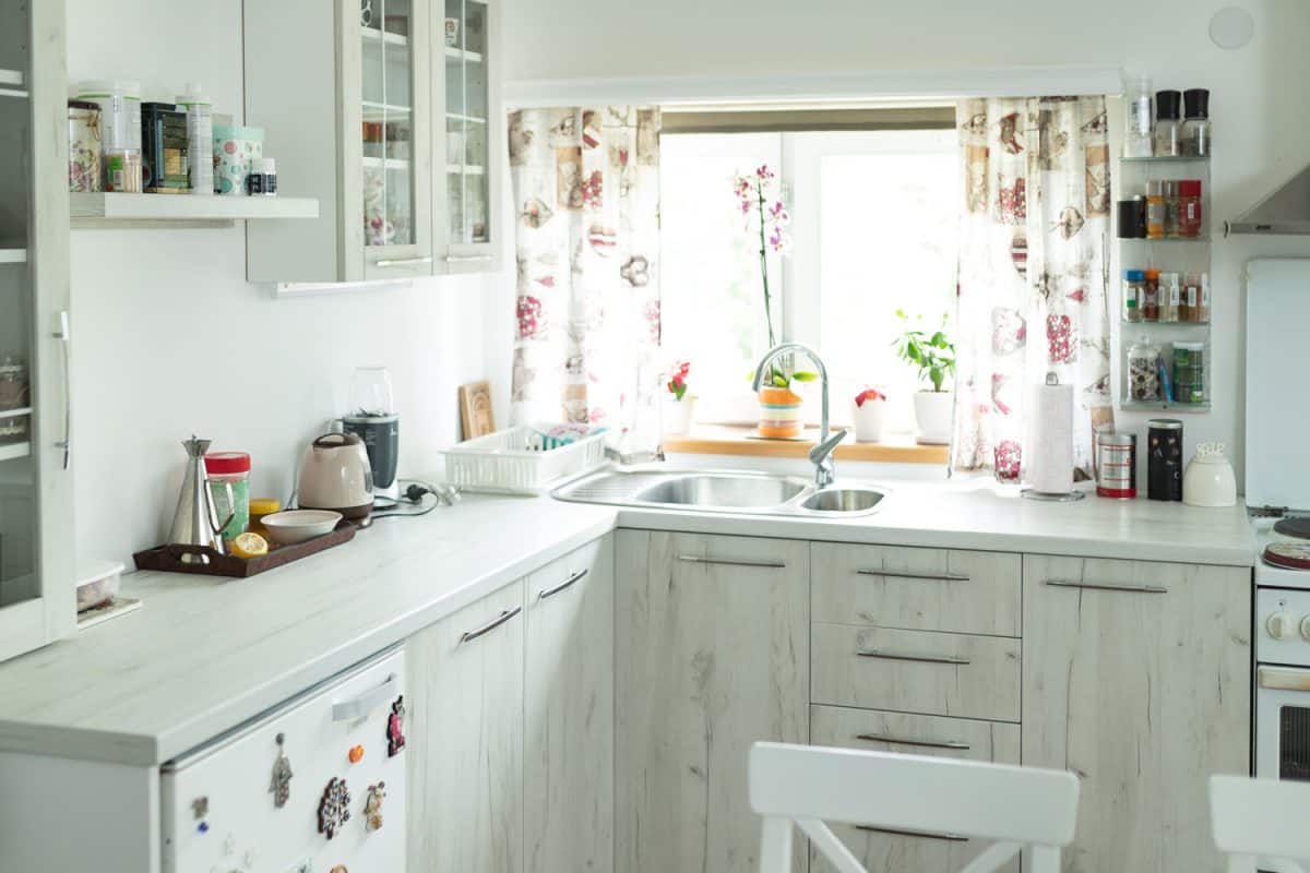 白色的启发与白色的橱柜和厨房白色台bd手机下载面一个窗口装饰着鲜花和植物的设计窗帘