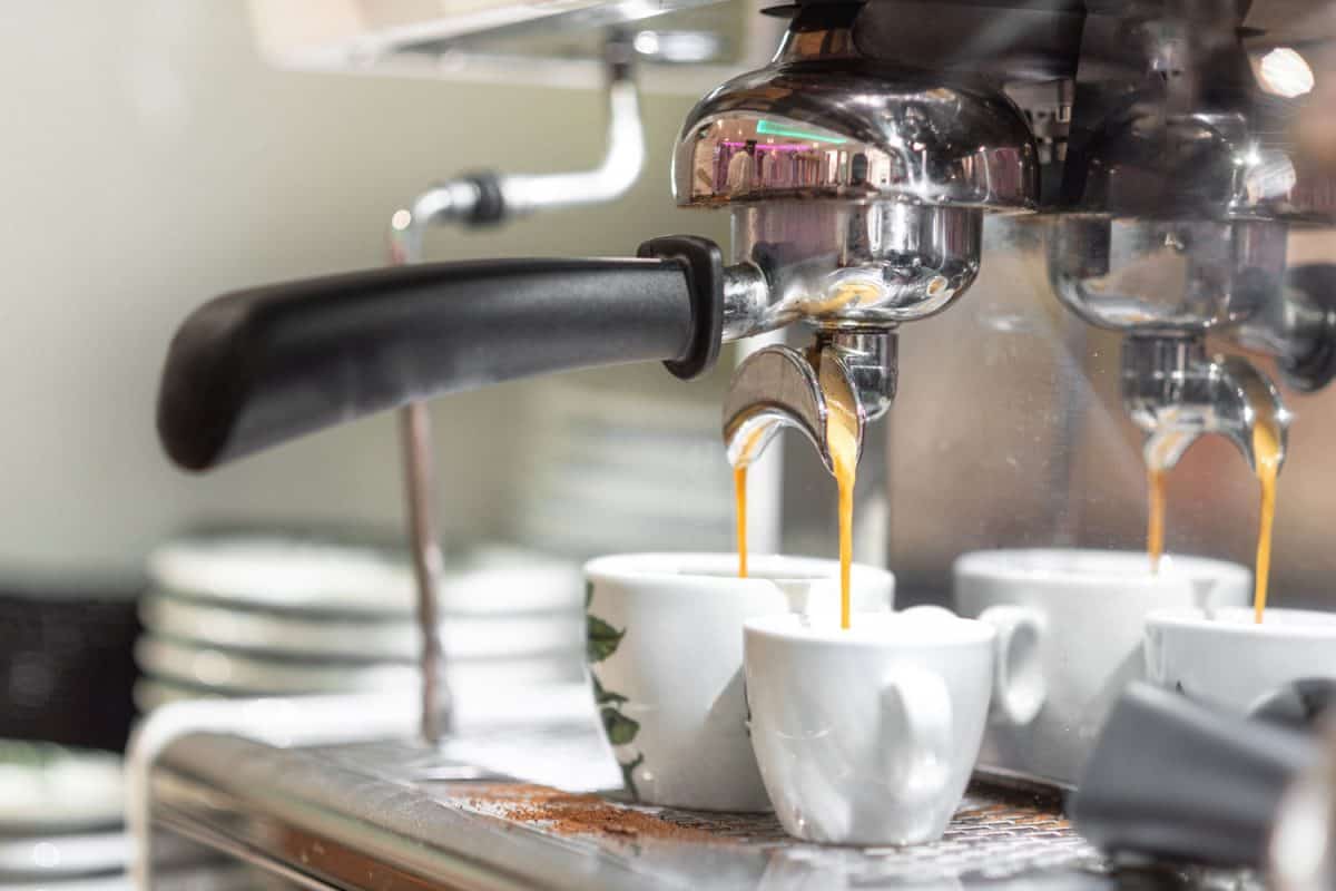 咖啡店里一台浓缩咖啡机正在倒两杯咖啡