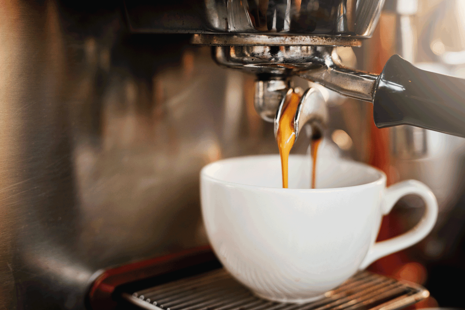 特写镜头，一个浓缩咖啡机倒咖啡到一个杯子里的咖啡馆