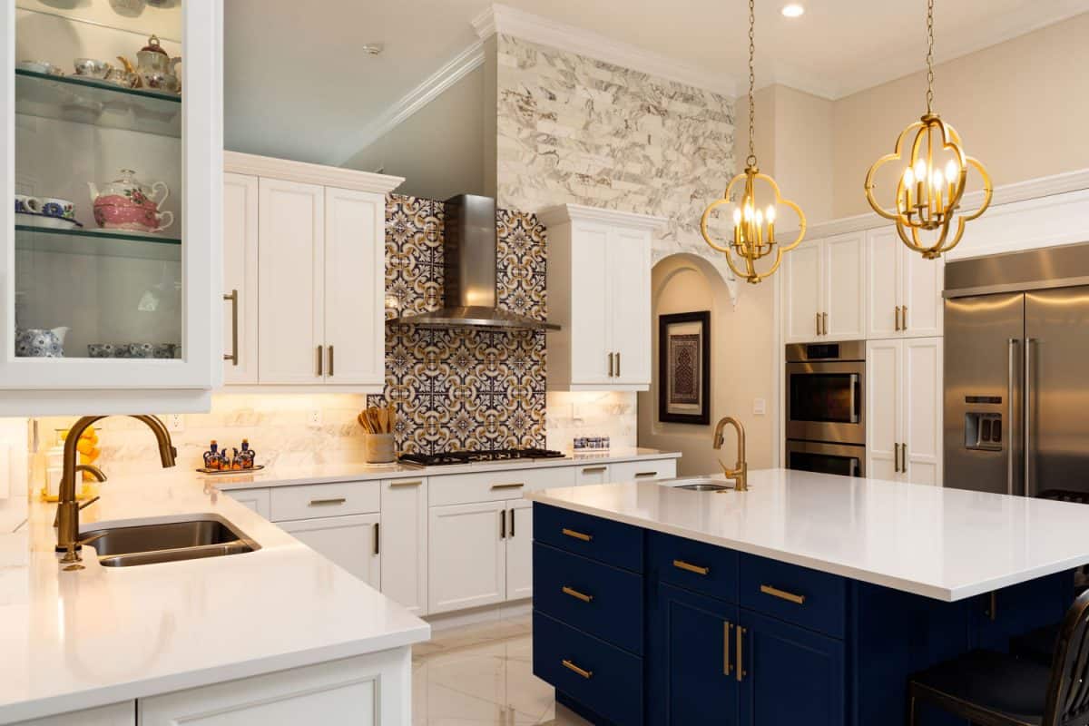 豪华现代设计的厨房，白色厨房台面，白色橱柜，早餐吧的bd手机下载深蓝色橱柜