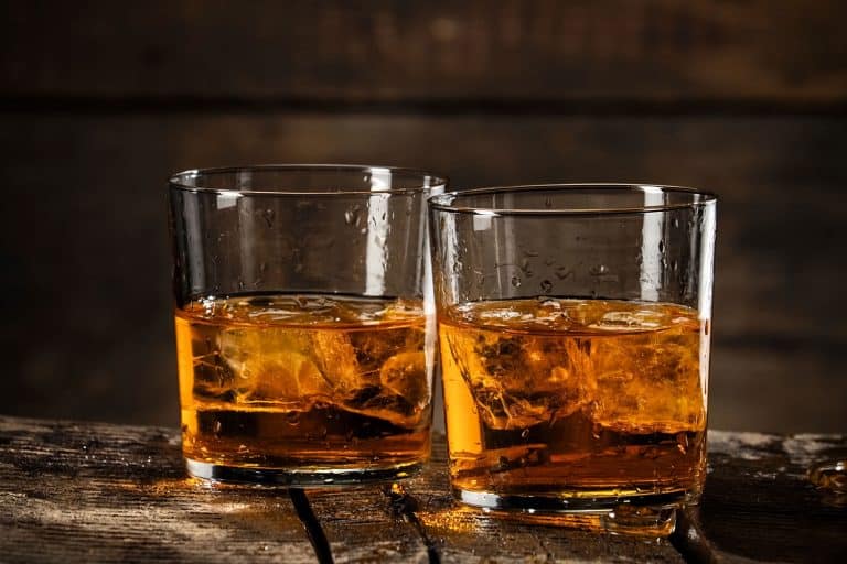 两杯威士忌加冰块，木制背景，你应该多久换一次酒杯?