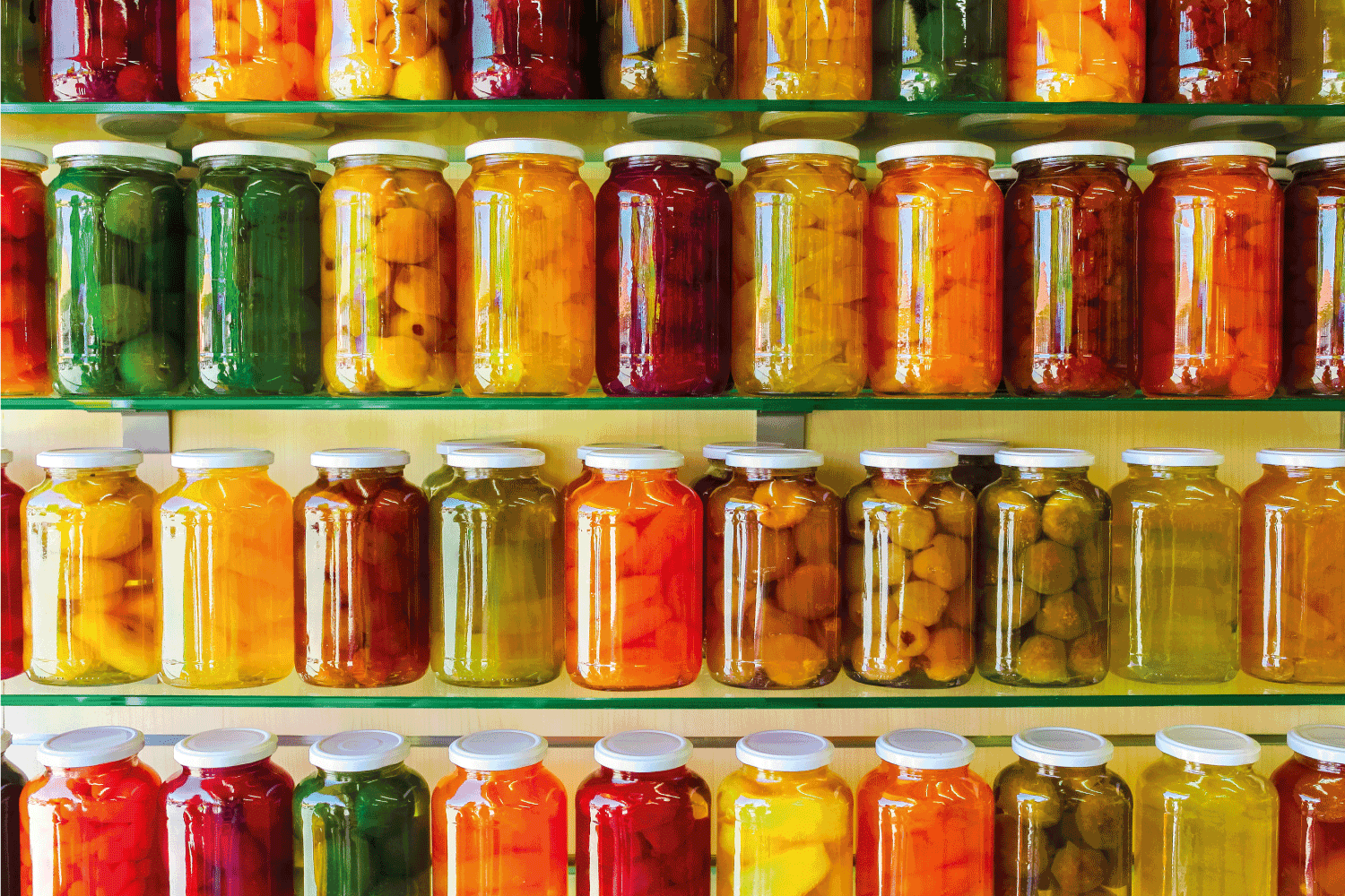 玻璃架子上有各种各样的罐装水果和蔬菜果酱罐