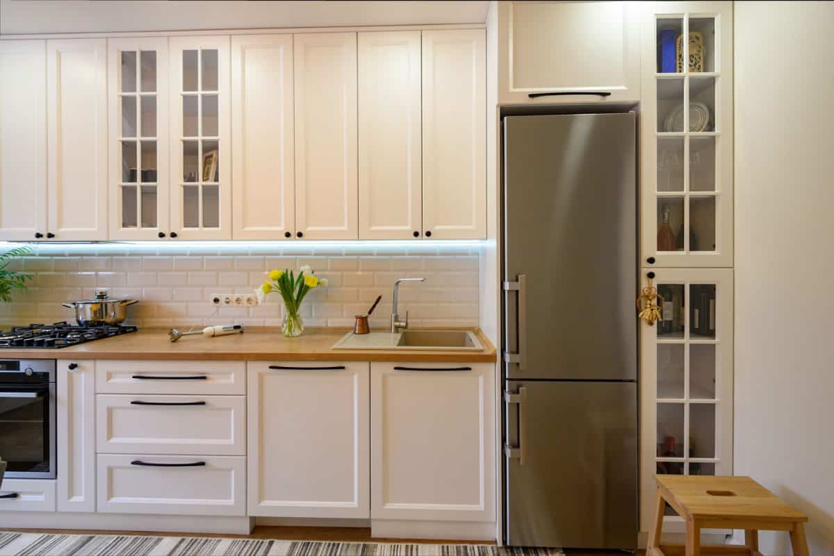 现代化厨房里的冰箱，白色橱柜和木质台面bd手机下载