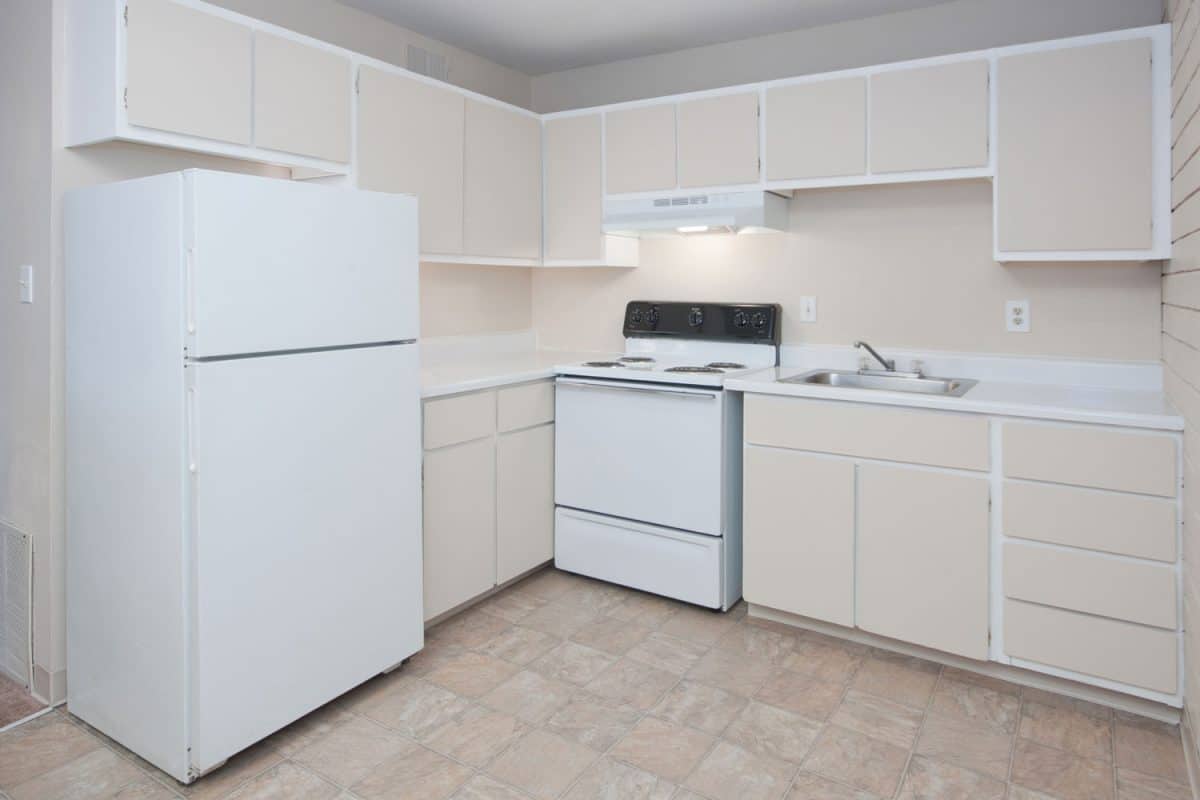 极简主义风格的厨房，浅棕色的橱柜和角落里bd手机下载的白色冰箱