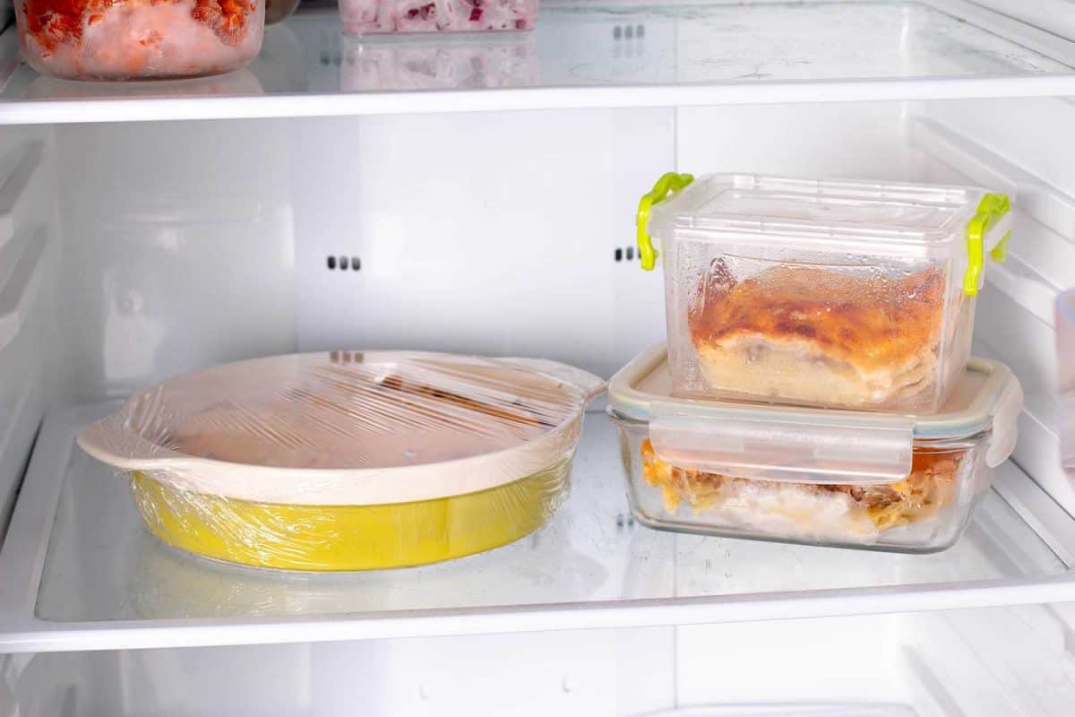 在容器和冷冻食品在冰箱里架子上烤碟中