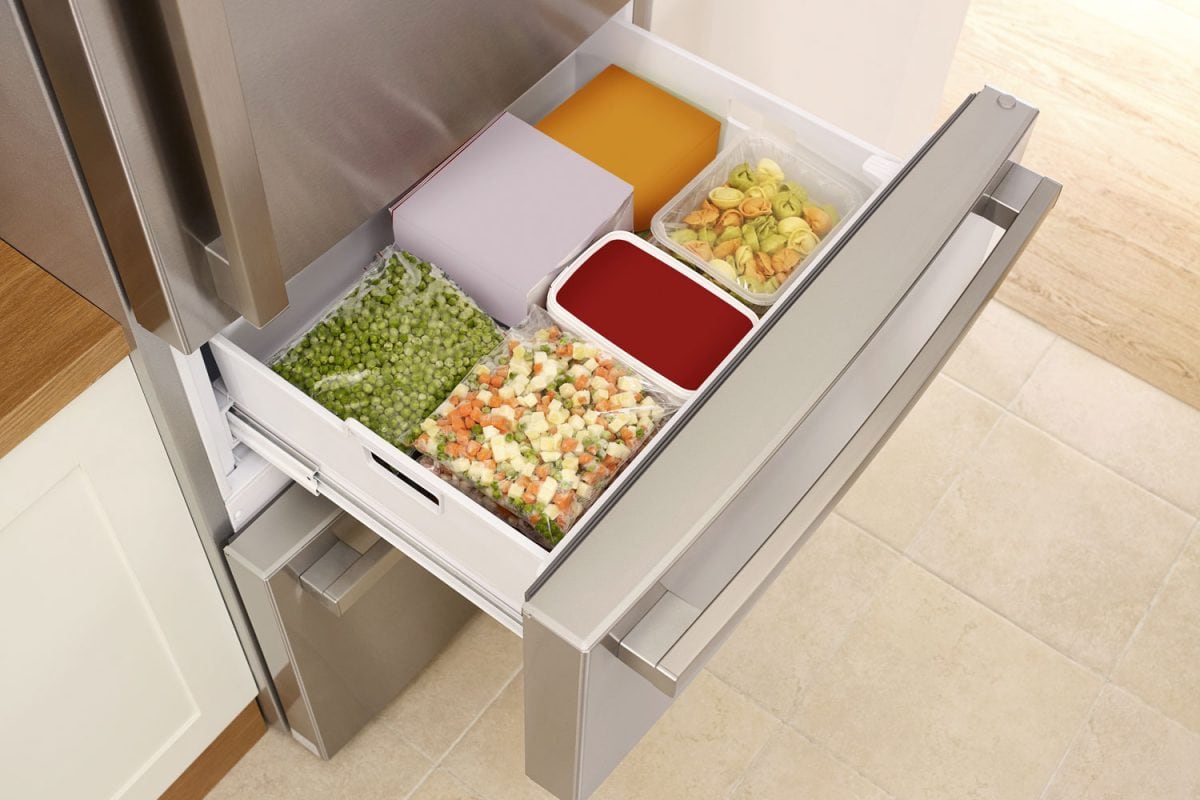 冰箱打开的抽屉里装满了蔬菜和其他豌豆