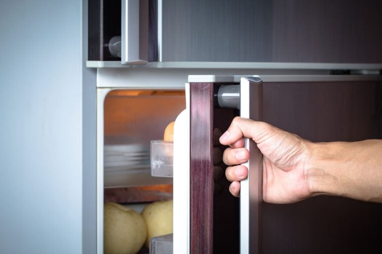 抽象的手一个年轻人打开冰箱的门,如何打开和关闭LG冰箱的门报警