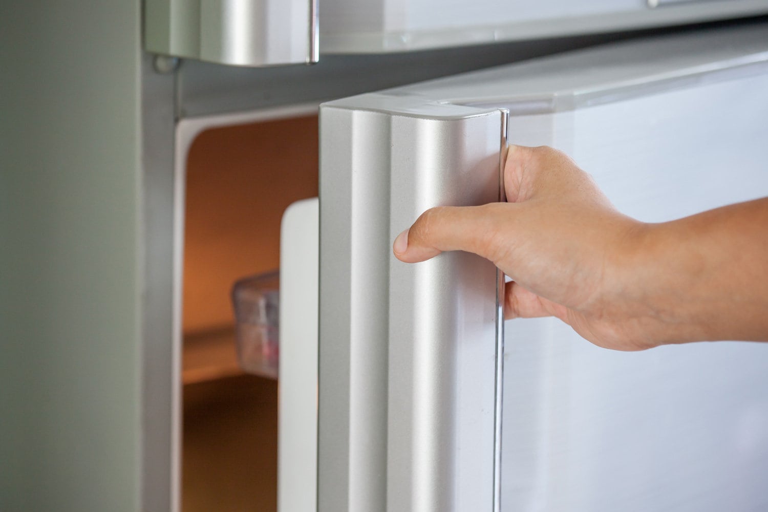 女人用手打开冰箱门