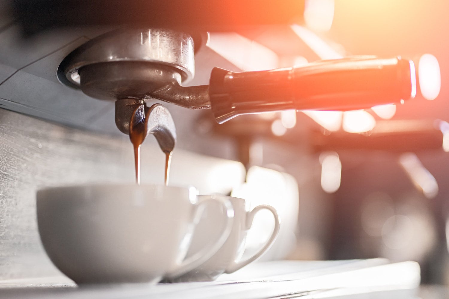 咖啡机倒咖啡在杯子里，低角度咖啡机倒新鲜芳香的浓缩咖啡在小马克杯在咖啡馆