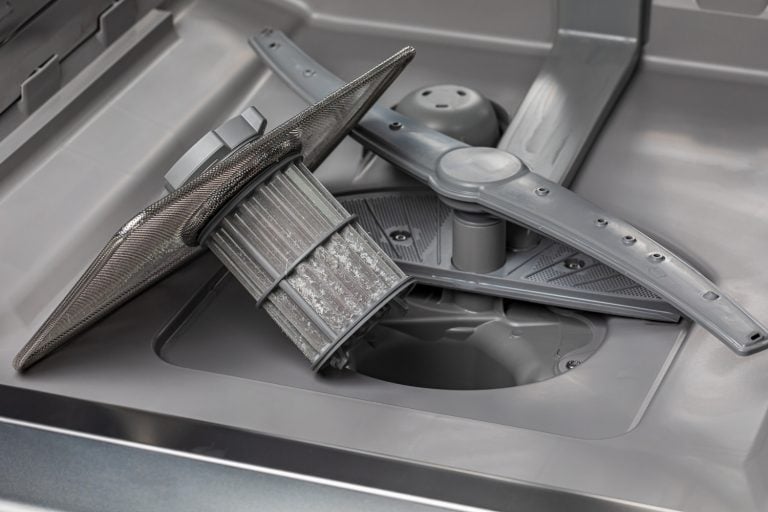 洗碗机在洗碗机的滤网。家电维修、维护和服务理念。——如何清洁堵塞洗碗机喷雾武器