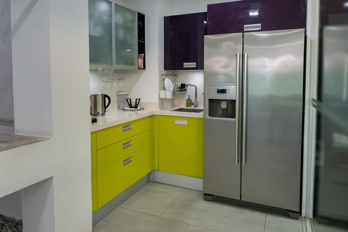 一个现代化的小厨房，薄荷绿色的bd手机下载橱柜和白色的台面与整体设计相匹配