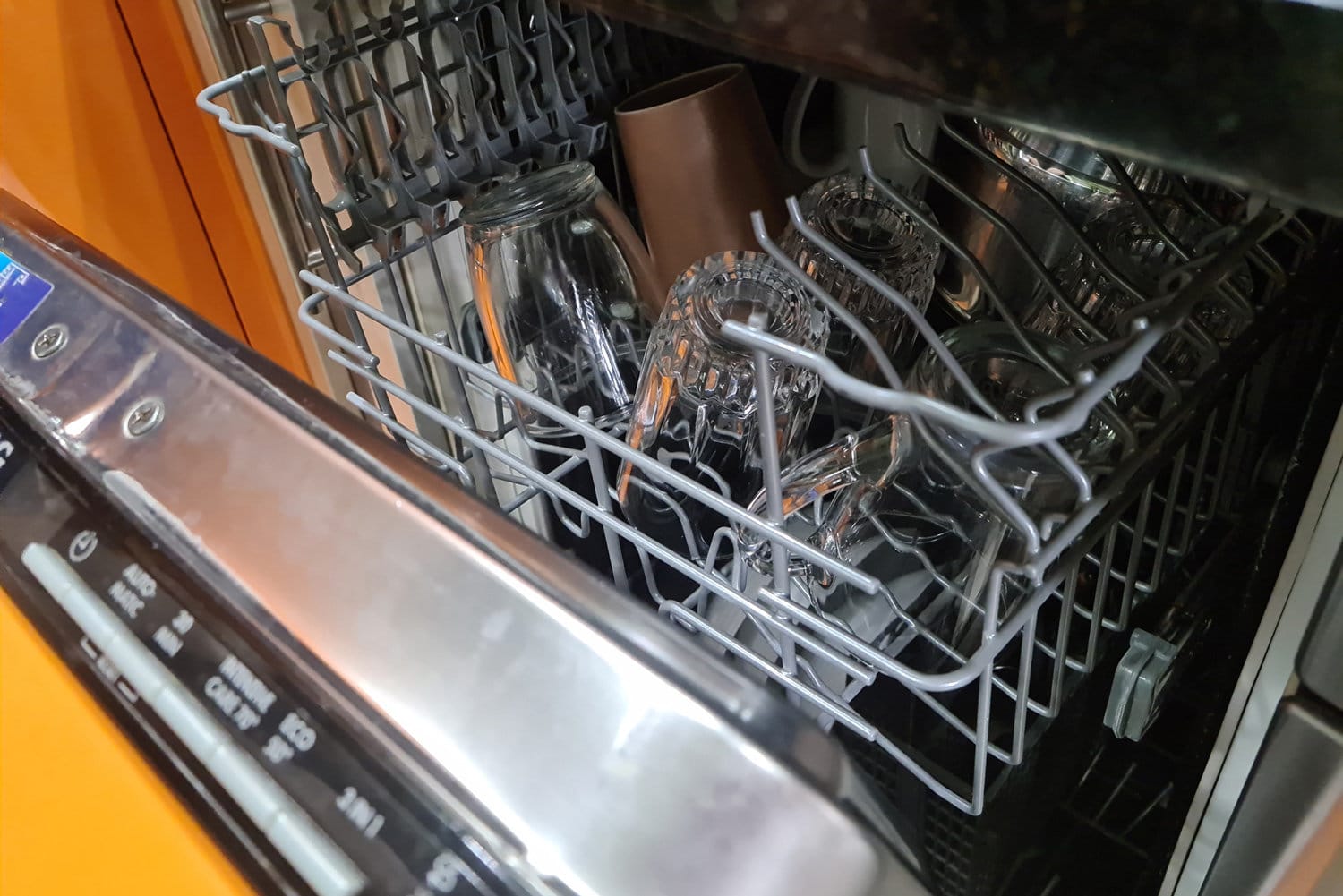丢失了带有干净玻璃杯和盘子的开放式洗碗机。洗碗和家用电器的概念