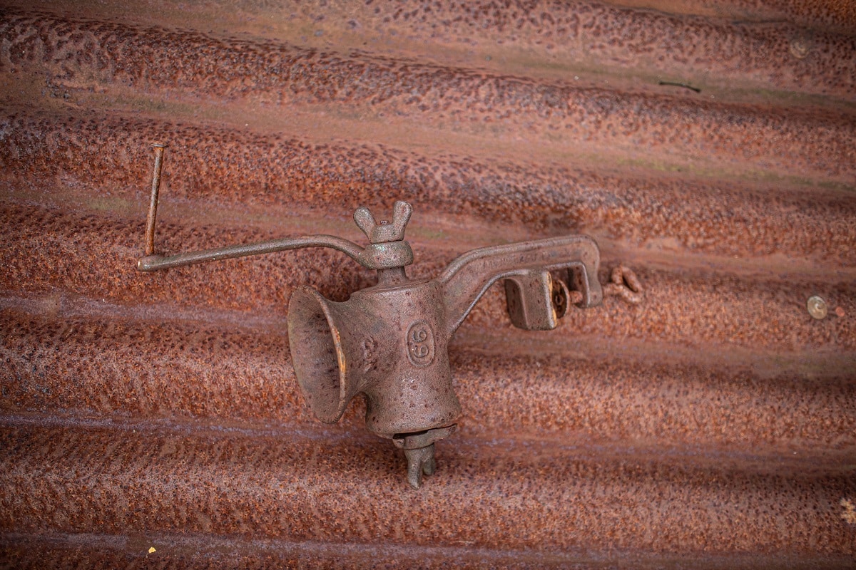 如何修复一个老绞肉机——真的生锈的老绞肉机坐在一个同样生锈的波纹屋顶板上