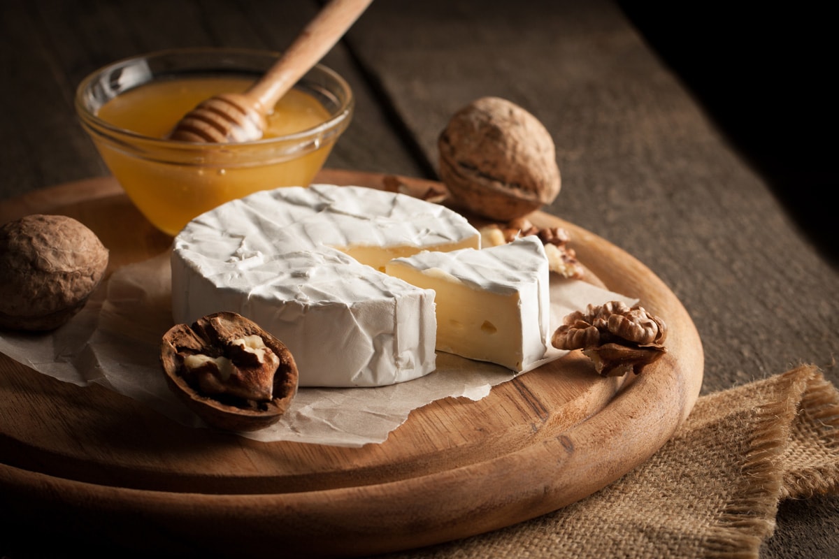 质布里干酪奶酪木制背景与坚果香料和大蒜。