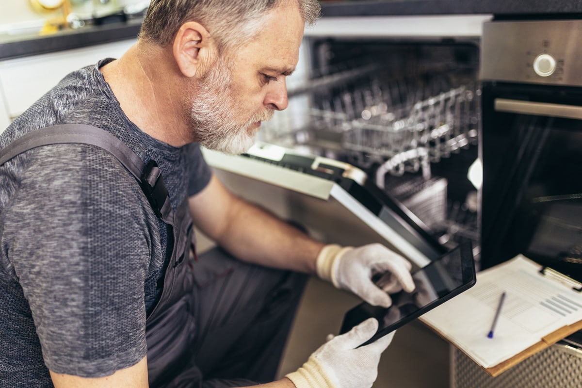 男性技师在厨房修理洗碗机的肖像bd手机下载