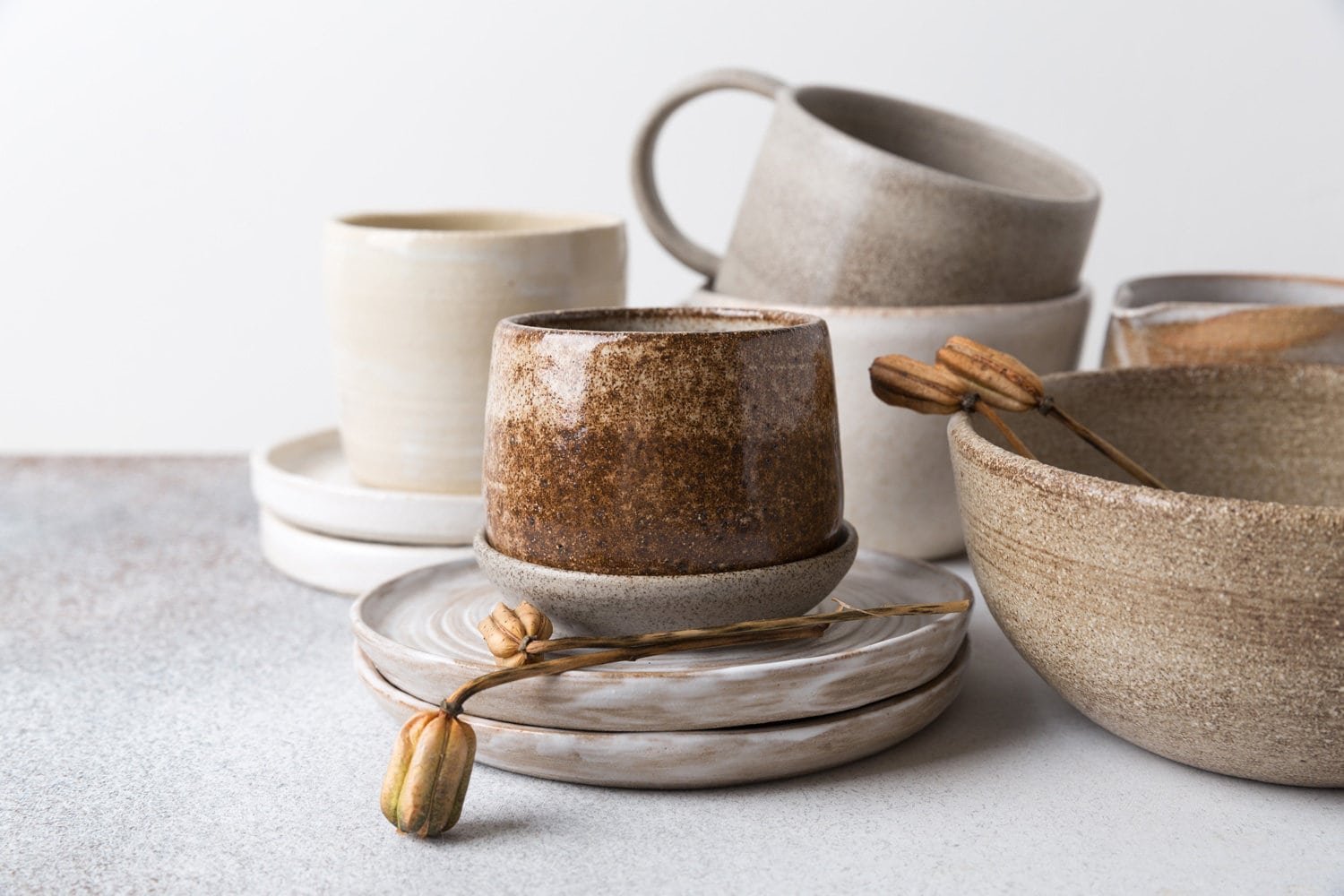陶瓷餐具套装。空的工艺陶瓷盘子，碗和杯子在浅色的背景上。