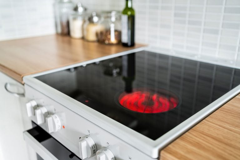 炉子和炊具红色热。感应、陶瓷炉灶面、电加热和滚刀在厨房,Corningware感应炉灶面吗?bd手机下载——它可以用于烹饪?应该吗?