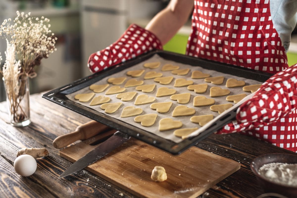 生的自制的心形饼干放在烤盘上烘烤。新鲜的自制蛋糕或情人节的惊喜。